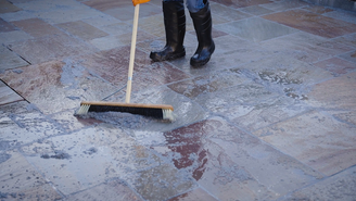 Contractor brushes resin grout into joints