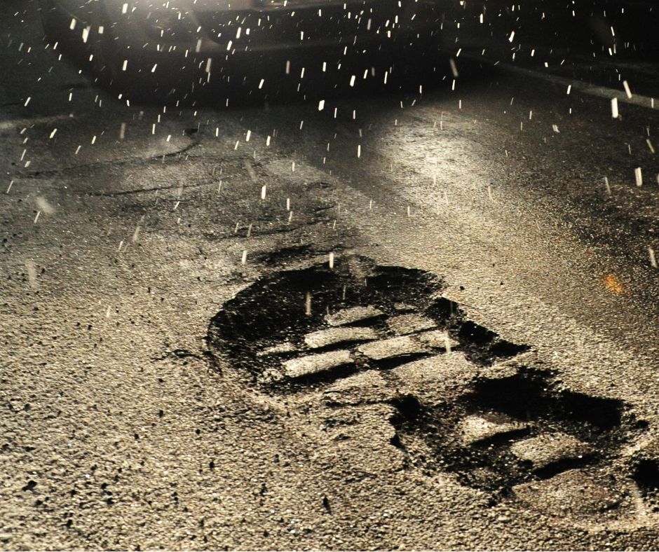 Pothole on tarmac road in winter